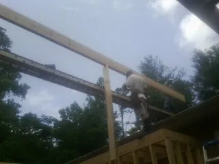 Carpenter setting a ridge beam over a new addition frame — Ice Dam Removal by Roofing Brothers in Ridgeway