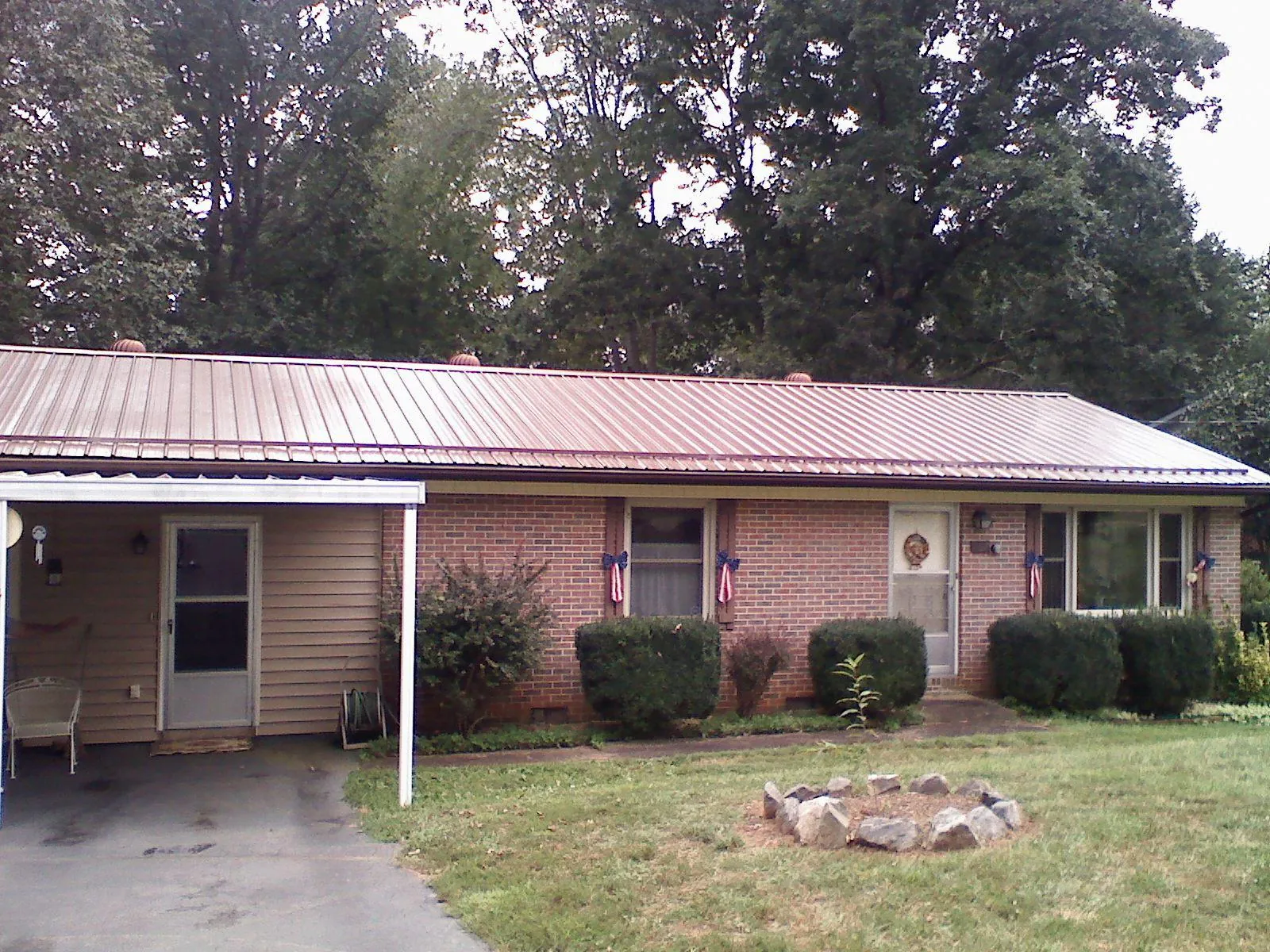 Bronze metal roof and carport on a brick ranch home — Roof Repair work by our crew in Ridgeway